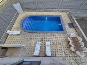 a large swimming pool with two chairs and two at Villa by HomeLand in Khujand