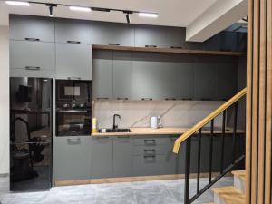 a kitchen with white cabinets and a sink at Villa by HomeLand in Khujand