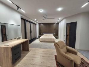 a bedroom with a bed and a tv and a chair at Villa by HomeLand in Khujand +18 photos