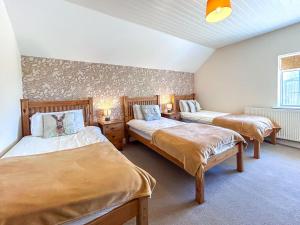 a bedroom with two beds and two tables and a window at 6 Bed in Filey oc-94524 in Reighton