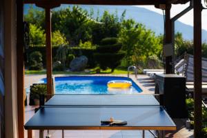 a ping pong table in front of a swimming pool at Villa Manevi in Yavornitsa