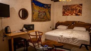 a bedroom with a bed and a desk with a computer at MivanUrfa Otel in Urfa