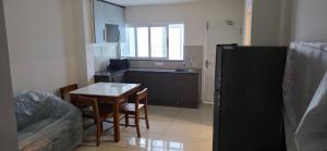 a small kitchen with a table and a refrigerator at Lucy Residences in Ernakulam