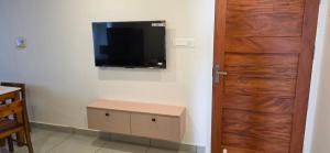 a room with a door and a television on a wall at Lucy Residences in Ernakulam
