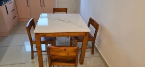 a table and four chairs in a kitchen at Lucy Residences in Ernakulam