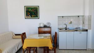 un soggiorno con divano, tavolo e cucina di Olympos Studios ad Amoopi Altre 51 foto