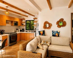 a living room with a couch and a kitchen at Principitos Universe in San Juan La Laguna