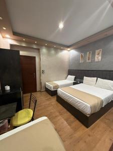 a hotel room with two beds and a desk and a table at Cairò Plàza, Ravexa Hotel in Cairo