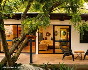 a house with a tree in the foreground at Principitos Universe in San Juan La Laguna