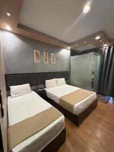 a bedroom with two beds and a shower at Cairò Plàza, Ravexa Hotel in Cairo
