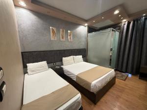 a bedroom with two beds and a shower at Cairò Plàza, Ravexa Hotel in Cairo