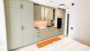a kitchen with white cabinets and an orange rug at Terrasstudion - Borgholm in Borgholm