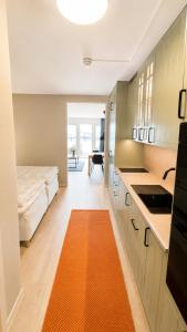 a kitchen with a bed and a orange rug in a room at Terrasstudion - Borgholm in Borgholm