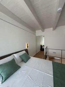 a bedroom with a large white bed with green pillows at Tradomari in Mesagne