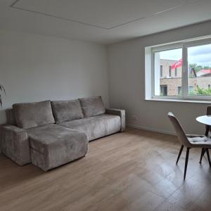 a living room with a couch and a table and a window at Melnragė, Molo g in Melnragė
