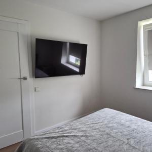 a bedroom with a flat screen tv on the wall at Melnragė, Molo g in Melnragė