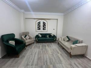 a living room with two green chairs and a couch at Safa A house in Sintrīs
