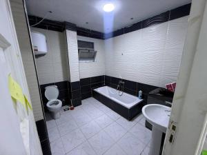 a bathroom with a tub and a toilet and a sink at Safa A house in Sintrīs