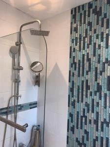 a shower in a bathroom with a shower curtain at Williton Guest House in Luton