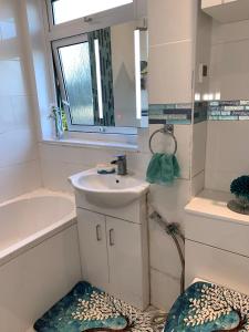 a bathroom with a sink and a mirror at Williton Guest House in Luton +12 photos