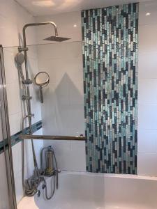 a shower in a bathroom with a shower curtain at Williton Guest House in Luton