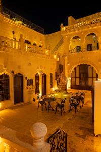 a courtyard with tables and chairs in a building at night at MivanUrfa Otel in Urfa