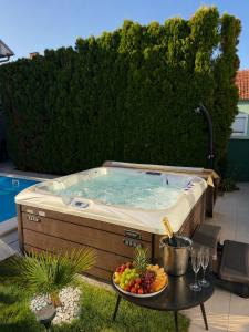 a hot tub on a patio with a table with fruit at Vila DeLux in Negotin
