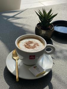 a cup of coffee on a plate with a spoon at Vila DeLux in Negotin +81 photos
