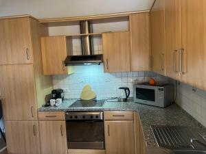 a kitchen with wooden cabinets and a microwave at DADI Apartment in Linz am Rhein