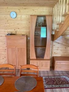 a dining room with a table and chairs and a clock at Dolina Nataci in Nidzica