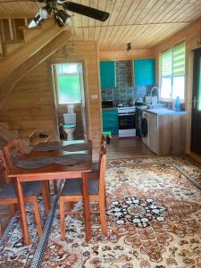 a kitchen with a table and chairs in a cabin at Dolina Nataci in Nidzica