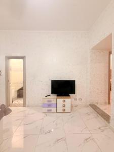 a living room with a tv on a white wall at Via Acquedotto 54 in Olbia