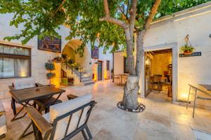 a patio with a tree and tables and chairs at Arcus Cappadocia in Göreme