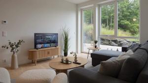 a living room with a couch and a tv at The Haven II - Cozy 2BR Voss - The Voss Collection in Vossevangen