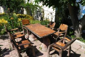 a wooden table and chairs sitting next to a tree at KILIÇ MOTEL in Istanbul