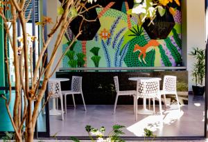 a room with tables and chairs and a colorful wall at Hm Express in Colima
