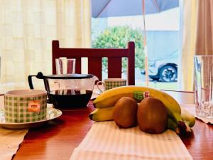 a table with a bunch of bananas and fruit on it at Moradia Vila Real Sto Antonio in Vila Real de Santo António