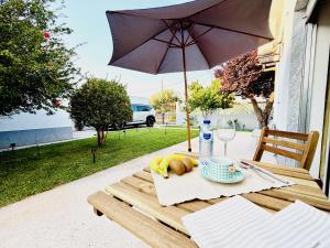 a table with a plate of food and an umbrella at Moradia Vila Real Sto Antonio in Vila Real de Santo António