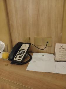 a telephone sitting on a desk with a glass of orange juice at فندق لوكس جراند in Dubai