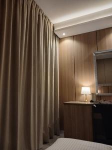 a bed room with a curtain and a lamp at فندق لوكس جراند in Dubai