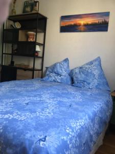 a bedroom with a blue bed with a blue comforter at L'Hysope Gap, Maison d'hôtes contemporaine avec vue in Gap