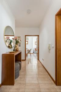 a hallway with a mirror and a table at Cinfães Centro Stay in Cinfães