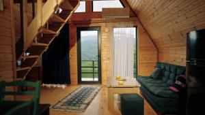 a living room with a couch and a large window at Kesane Cottages in Racha in Oni