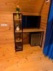 a room with a tv and a shelf with a television at Kesane Cottages in Racha in Oni +5 photos