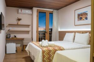 a hotel room with a bed and a balcony at Casarão Alpina in Mucugê