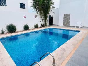 a swimming pool with blue water in a building at Depa Coralux in San Carlos