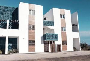 a white building with a sign in front of it at Depa Coralux in San Carlos
