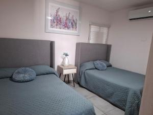 a bedroom with two beds with blue comforters at Depa Coralux in San Carlos