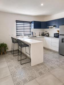 a kitchen with a white counter and blue cabinets at Depa Coralux in San Carlos