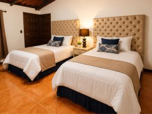 a hotel room with two beds and a headboard at Hotel Rincón Vallero in Valle de Anton